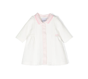 BOSS kidswear dress in off-white with light pink accents, featuring a premium cotton blend for comfort. This stylish dress includes a classic polo collar and long sleeves, perfect for young girls. The embroidered logo adds a designer touch, making it ideal for special occasions or everyday wear. Designed with a concealed front button fastening and a straight hem for a polished look, this dress is a must-have for fashionable kids. Available at Lestyle Boutique Melbourne.