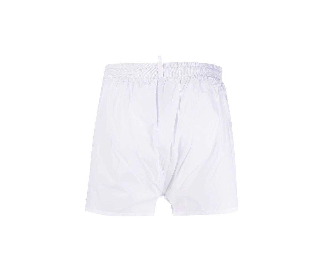 White shorts with colorful graphic design and 'Dsquared2' branding on a white background
