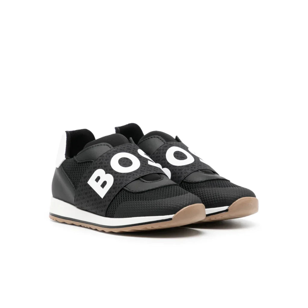 BOSS Kidswear logo-strap sneakers in black and white, featuring a stylish retro running silhouette. The elasticated logo strap provides easy slip-on access, making them perfect for active kids. With a reinforced toe and padded ankle. Ideal for casual outings or playdates, these sneakers combine luxury and practicality, available at Lestyle Boutique Melbourne.
