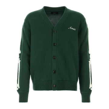 A forest green cotton cardigan by AMIRI, available at Lestyle Boutique. This cardigan features bone embroidery on the sleeves, a V-neck, front button fastening, and ribbed detailing for a stylish and contemporary look.