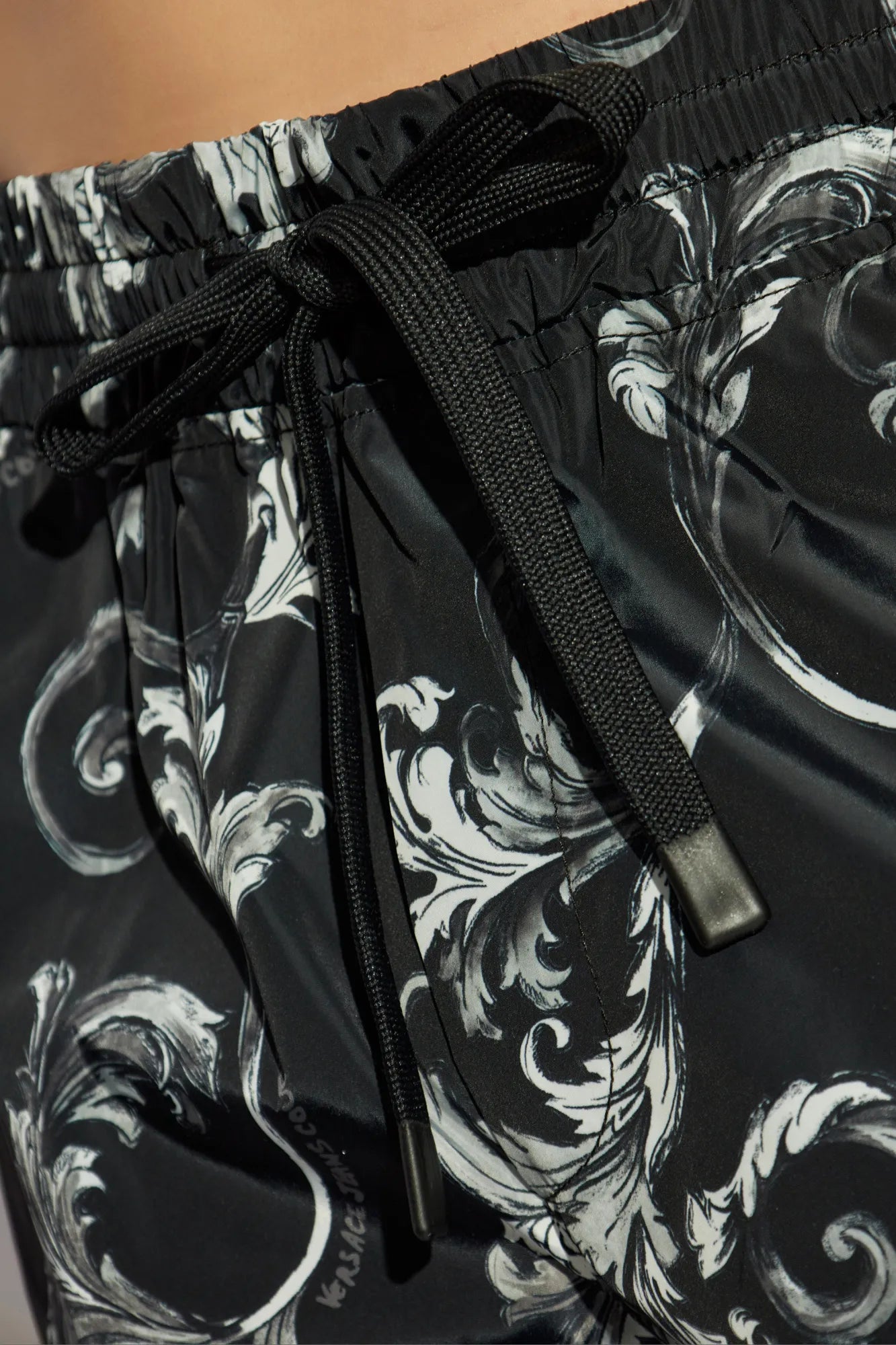 Versace Jeans Couture Logo Shorts in black, featuring an all-over Barocco-inspired print, elastic waistband, and lightweight fabric for maximum comfort and style, available at Lestyle Boutique.