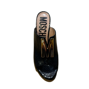 Moschino black textured heeled slide with an open toe, block heel, and large gold-tone 'M' logo hardware on the front strap, available at Lestyle Boutique 136 Little Collins St.