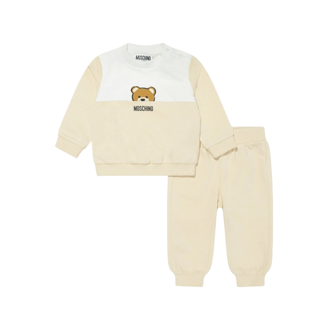 Moschino Kids Baby beige tracksuit set from the SS2025 collection, including a color-block (white/beige) sweatshirt with Teddy Bear motif and matching beige pants, available at Lestyle Boutique 136 Little Collins St.