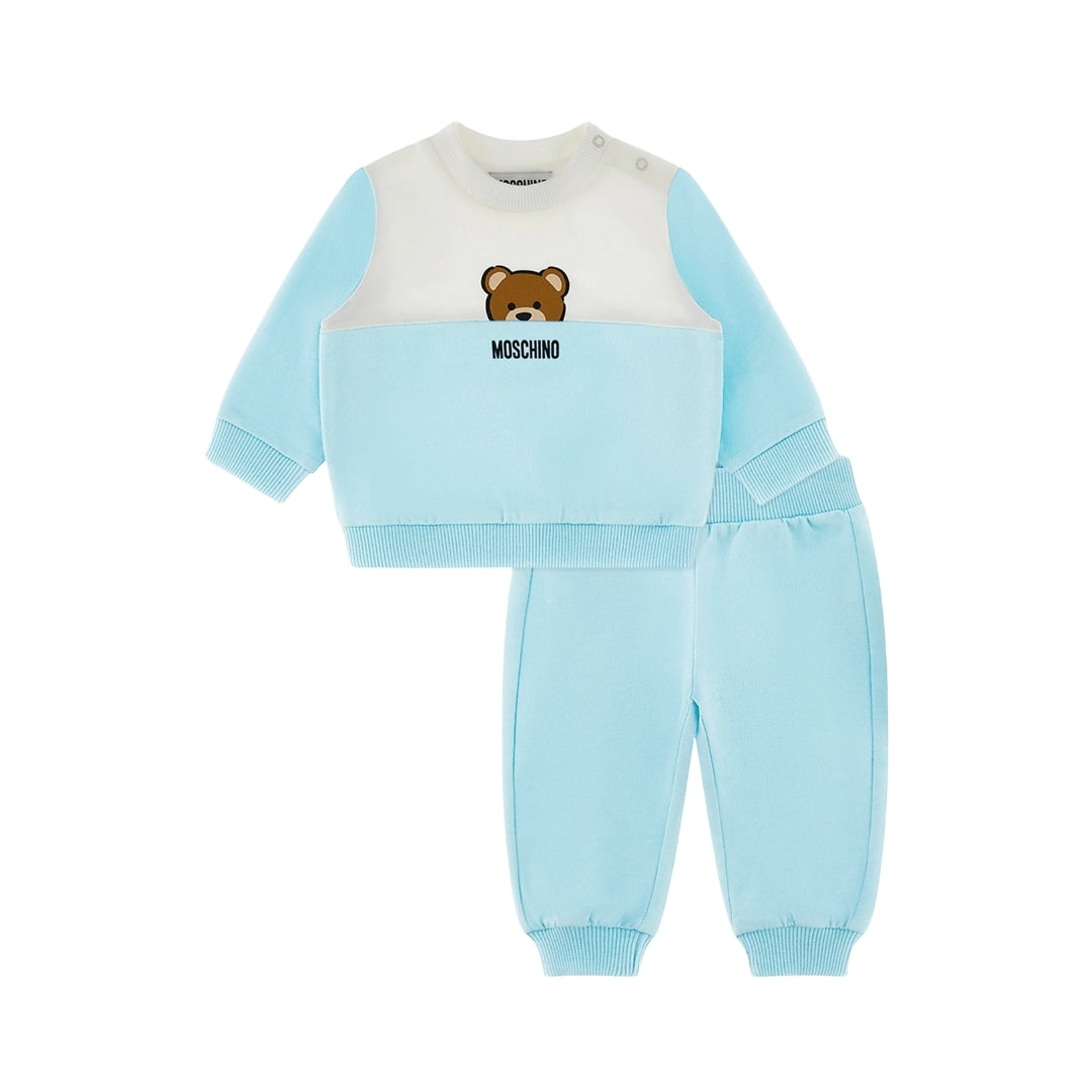Moschino Kids Baby light blue tracksuit set including a color-block (white/light blue) sweatshirt with Teddy Bear motif and shoulder snaps, and matching light blue pants, available at Lestyle Boutique 136 Little Collins St.