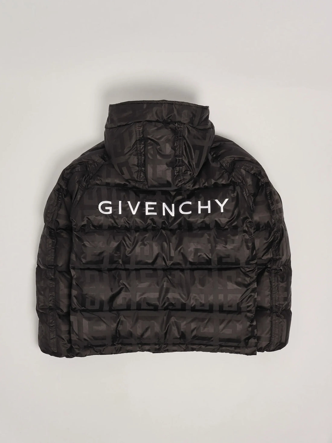 Givenchy boys black quilted nylon down jacket from the Winter 24/25 collection, featuring an all-over 4G logo pattern, fixed hood, GIVENCHY lettering on the back, and zippered side pockets, available at Lestyle Boutique 136 Little Collins St.