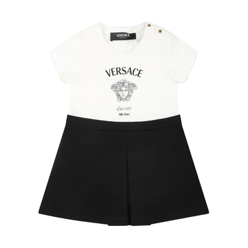 The Versace Black Dress for Baby Girl from Lestyle Boutique in a stylish white and black colour combination, featuring a cotton jersey top, flared Milano stitch skirt, and iconic Versace and Medusa logos on the front.