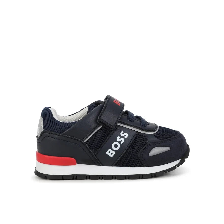 Stylish BOSS Kids navy sneakers featuring a comfortable design with a Velcro strap for easy wear. Constructed from a premium blend of leather and mesh, these shoes showcase red and white logo accents for a trendy look. Ideal for active children, these sneakers offer both style and comfort, making them perfect for everyday wear or casual outings. Available at Lestyle Boutique Melbourne.