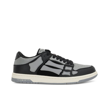 A pair of asphalt grey Skel Top low sneakers by AMIRI, available at Lestyle Boutique. Featuring sewn applications, two-tone rubber sole, and perforated details, these sneakers combine style and comfort effortlessly.