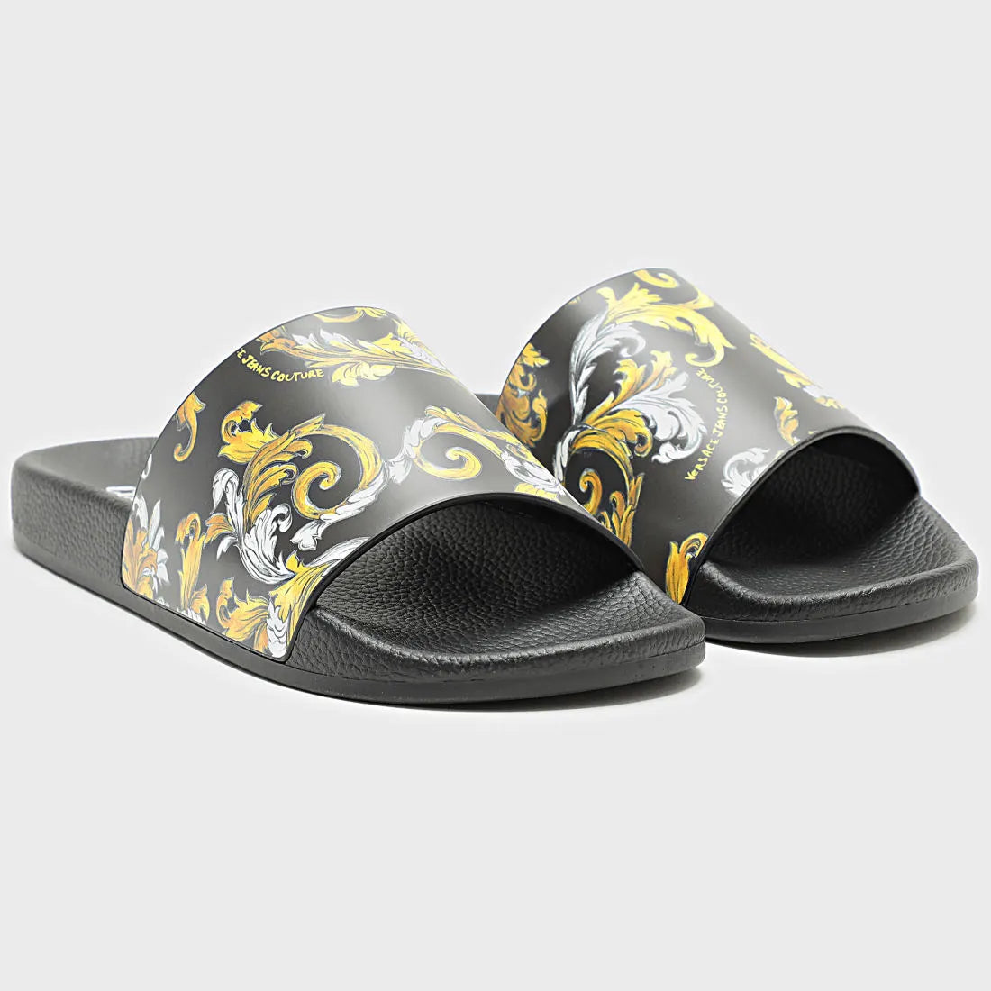 Versace Jeans Couture Fondo Slides in black with a striking gold Barocco print, featuring a branded strap and contoured footbed for ultimate comfort and luxury, available at Lestyle Boutique.