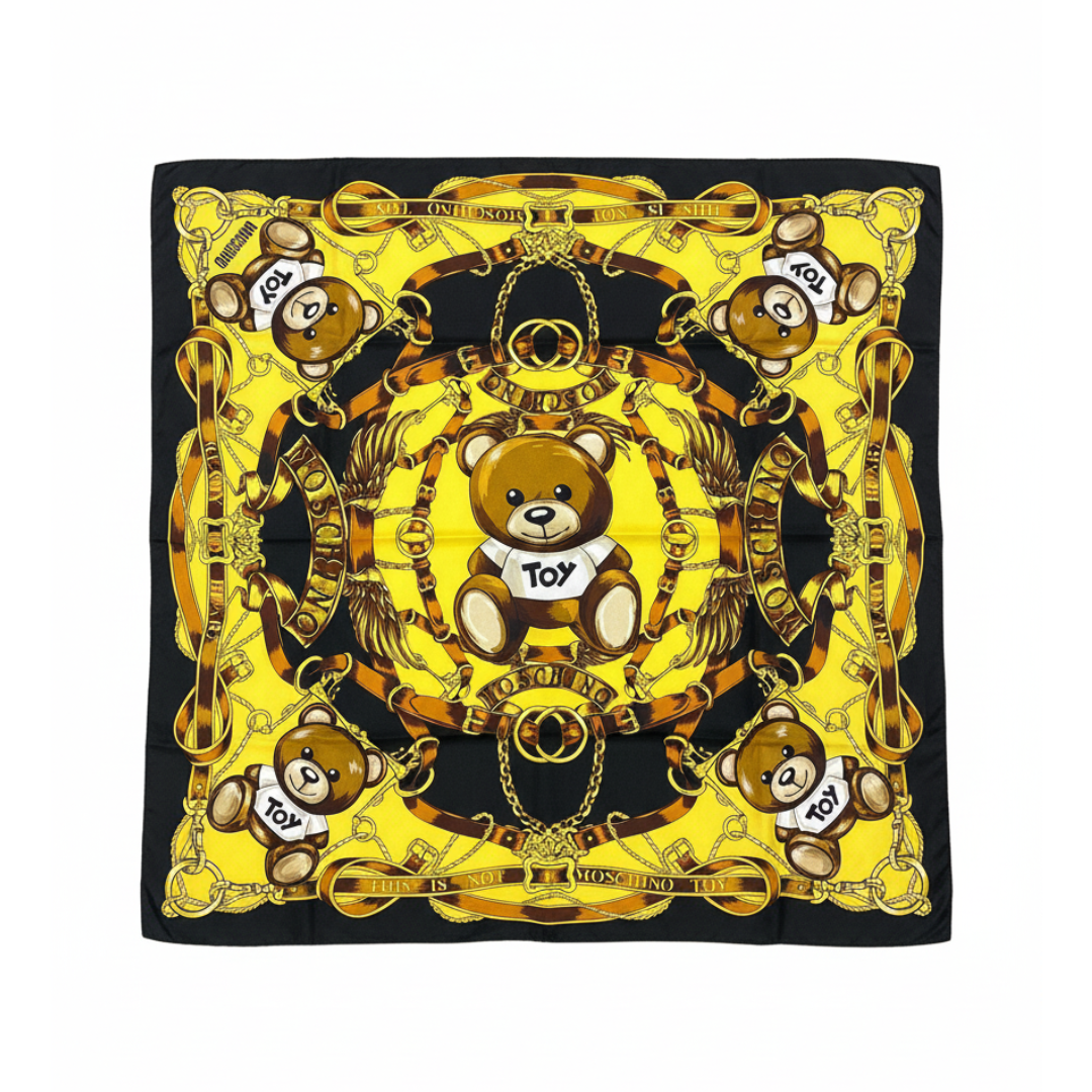 Moschino silk scarf featuring a bold yellow teddy bear and ornate golden chain motif available at Lestyle Boutique Melbourne
