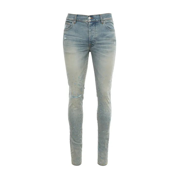 A pair of stretch stonewashed denim jeans by AMIRI, available at Lestyle Boutique. These jeans feature distressed details, a logo label at the back, belt loops, and a concealed button closure for a modern, rugged look.