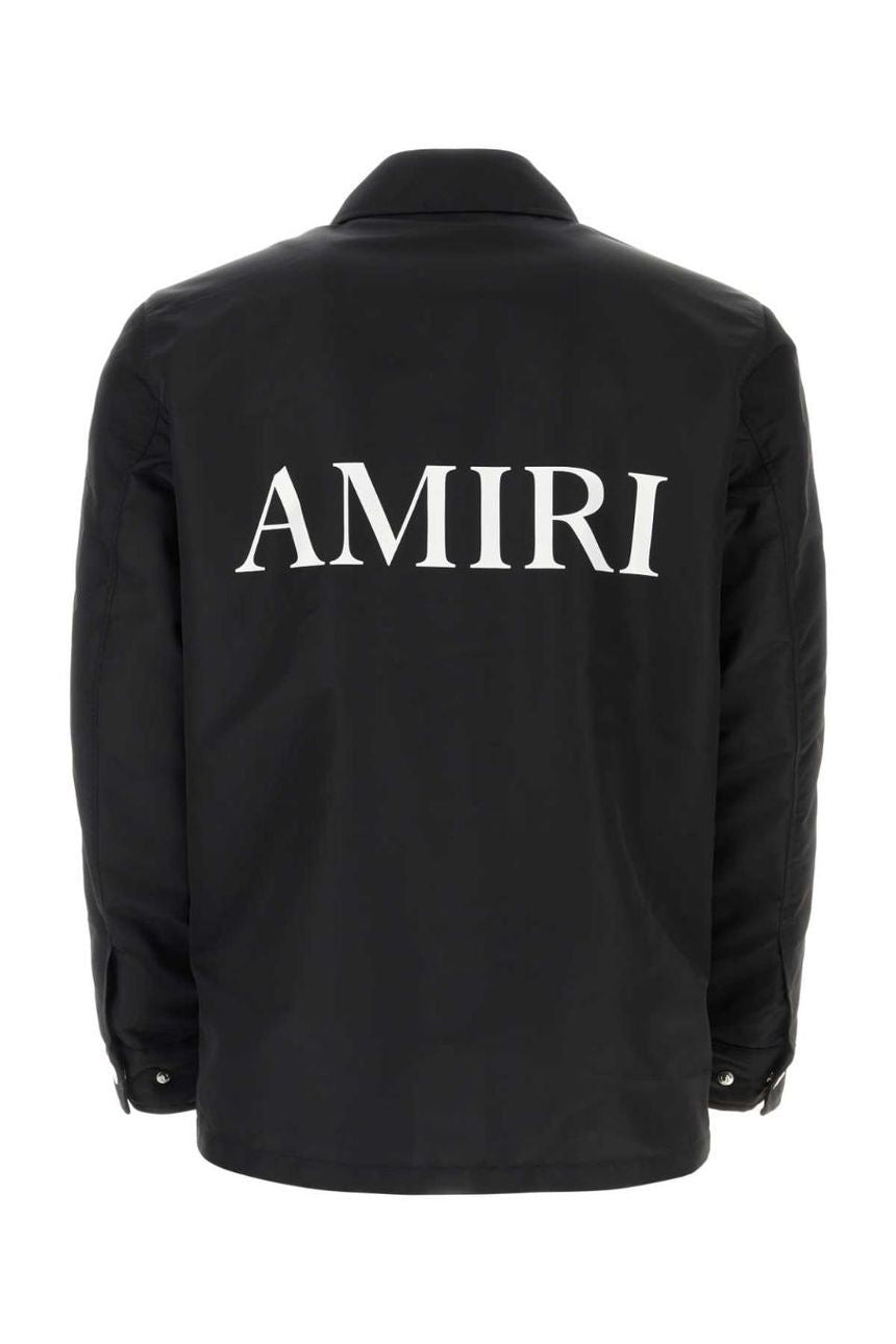 A sleek and lightweight black jacket by AMIRI, available at Lestyle Boutique. The jacket showcases embroidered logo details on both the chest and back, made from durable 100% nylon for a timeless look.