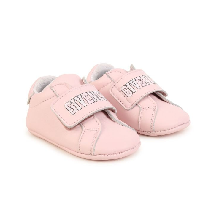 Pink baby shoes with Givenchy logo on a white background