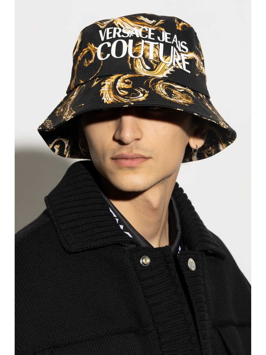 Versace Jeans Couture Black Bucket Hat featuring the iconic Barocco print in gold with a bold logo, offering a chic and modern accessory for elevated casual looks, available at Lestyle Boutique.
