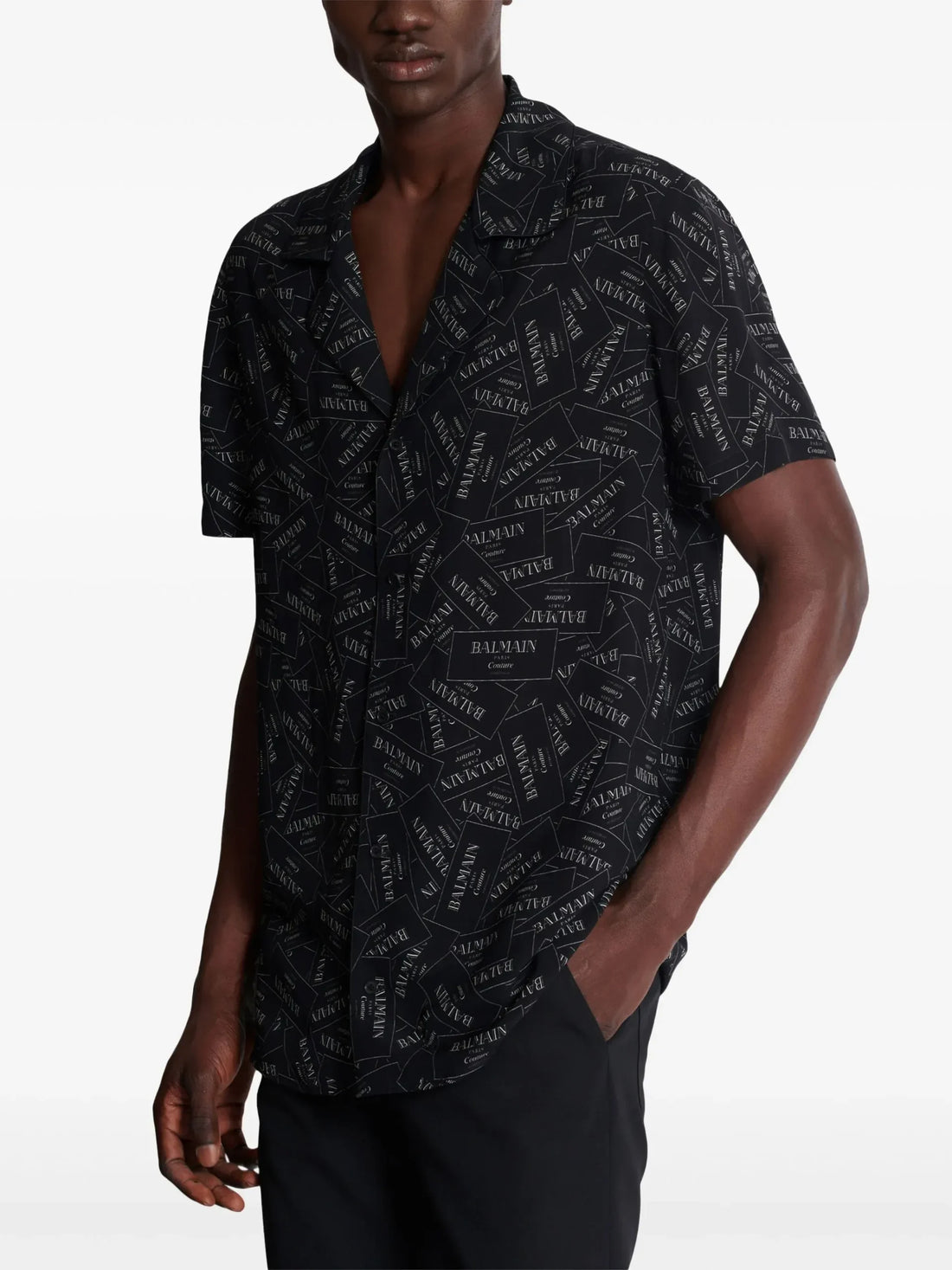 Balmain black short-sleeve shirt featuring an all-over logo print, poplin texture, and a notched collar, available at Lestyle Boutique.