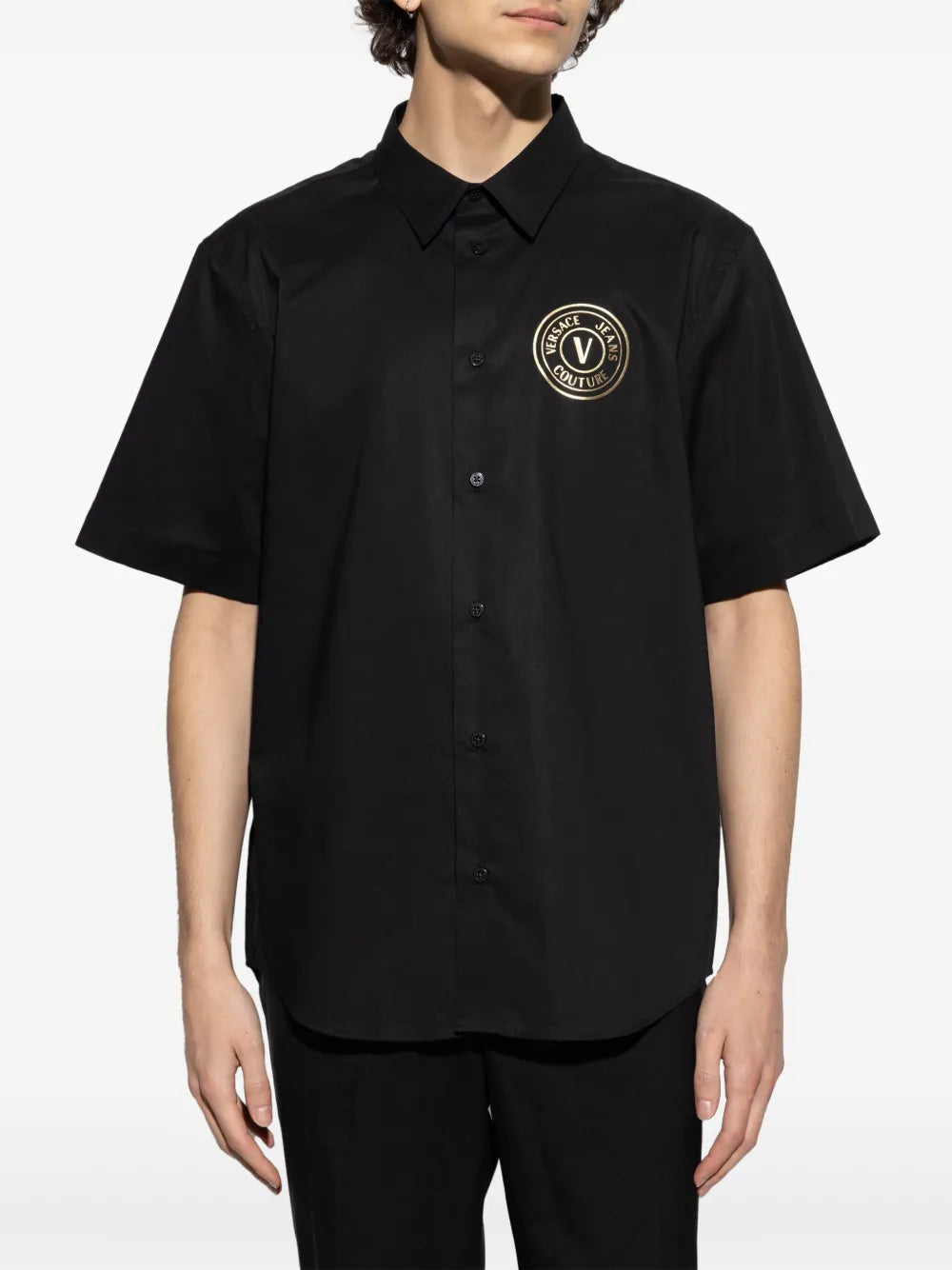 Versace Jeans Couture V-Emblem Short-Sleeve Polo Shirt in black, featuring the signature V-Emblem logo on the chest, a structured collar, and a short front button fastening, available at Lestyle Boutique.