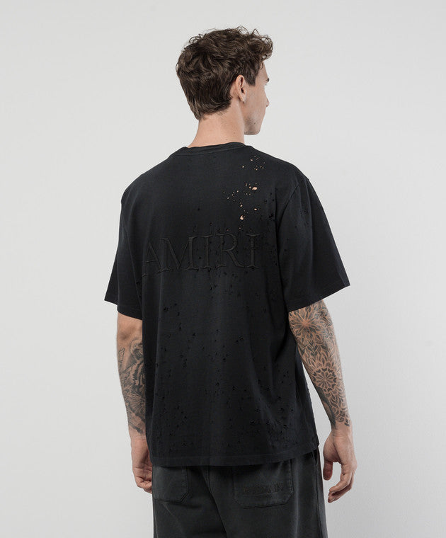 A black cotton t-shirt by AMIRI, available at Lestyle Boutique. Featuring a distressed vintage shotgun effect and tonal embroidered logo, this tee combines bold aesthetics with comfort.