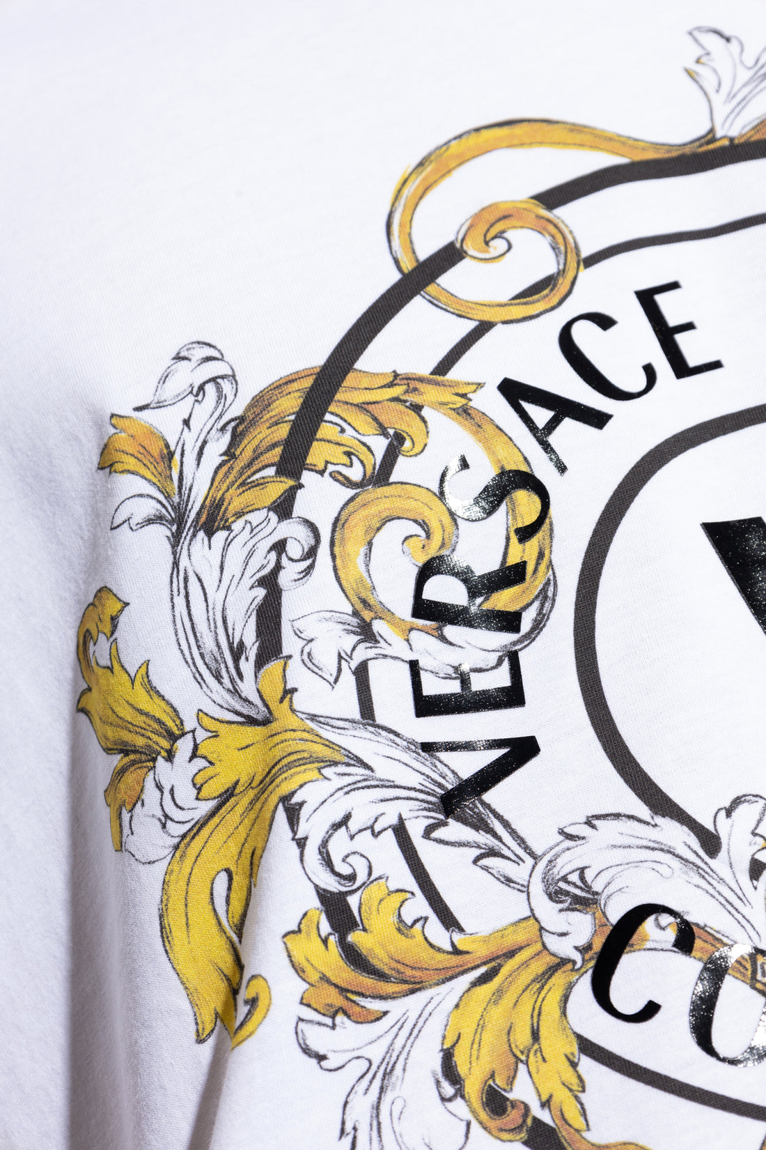 Versace Jeans Couture V-Emblem Printed Logo T-Shirt in white and gold, showcasing an intricate Barocco print surrounding the signature V-Emblem logo. A must-have luxury staple, available at Lestyle Boutique.