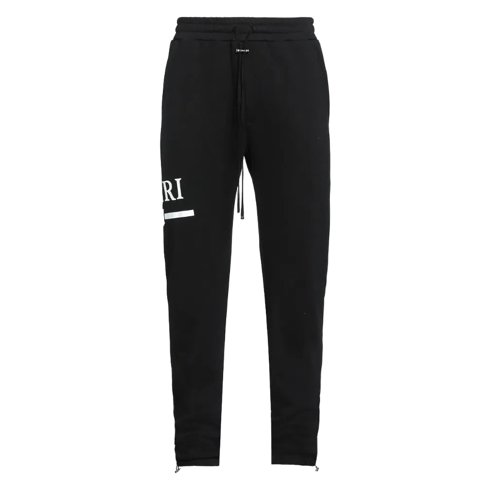 Black sweatpants with a white printed graphic on the left leg, featuring an elastic waistband with a drawstring and zippered cuffs.
