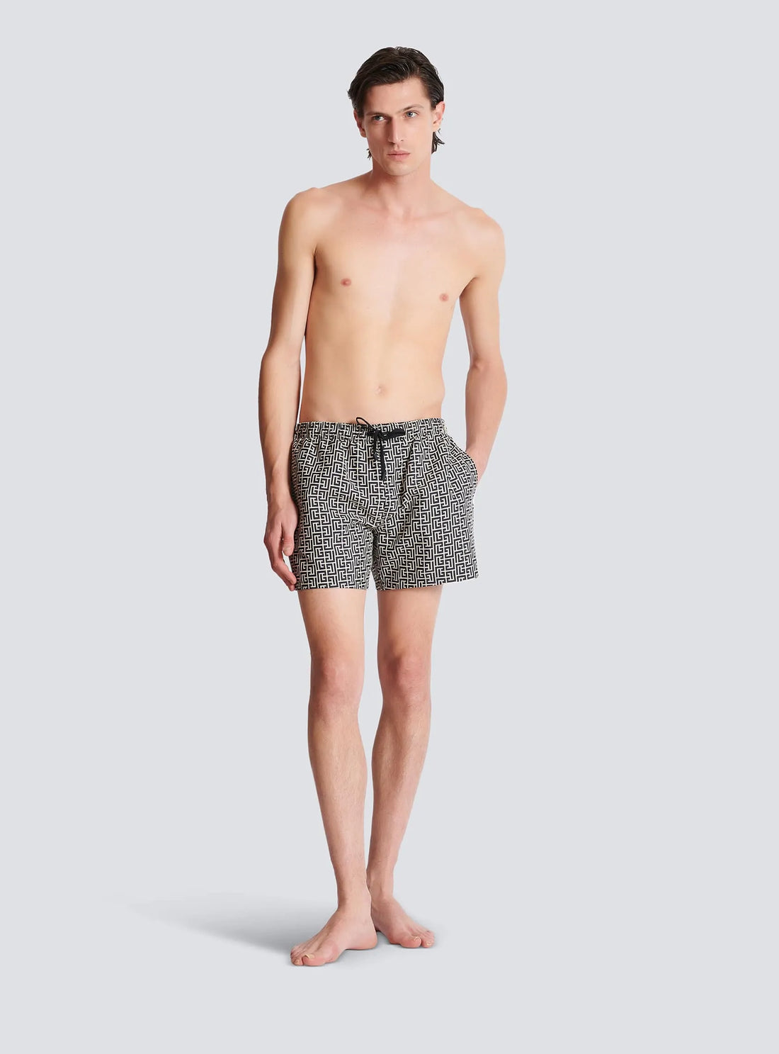 Balmain premium black swim shorts featuring a distinctive labyrinth print. These luxury designer swim shorts are designed with an elasticated waist for a comfortable fit and adjustable drawstring for added convenience. The stylish design includes side pockets and is perfect for beach outings or poolside lounging. Crafted with high-quality materials, these shorts ensure durability and a fashionable look. Ideal for the modern man seeking both style and comfort, available at Lestyle Boutique Melbourne.