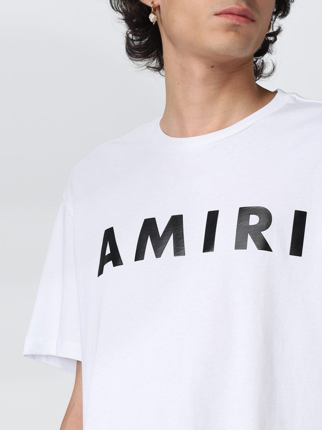 Amiri white cotton t-shirt featuring a bold black logo print across the chest. This premium designer piece showcases a relaxed fit and classic crew neck design, perfect for casual wear. The high-quality cotton fabric ensures comfort and durability, making it an ideal choice for everyday style or special occasions. Elevate your wardrobe with this luxury essential, available at Lestyle Boutique Melbourne.