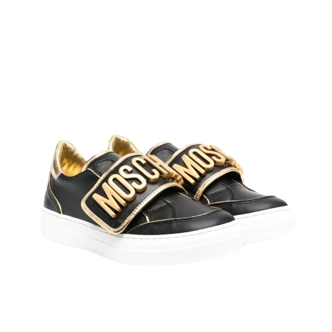 Moschino black sneakers with a white sole, featuring two Velcro straps with large gold Moschino logo lettering, available at Lestyle Boutique 136 Little Collins St.