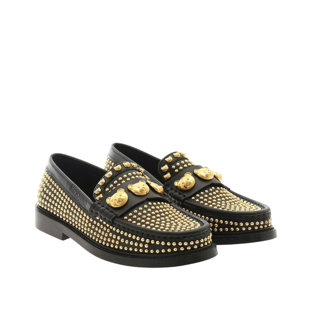 Moschino women's black calfskin leather loafers covered in golden metal studs, featuring a gold-tone Teddy Bear applique on the vamp and a cowhide leather sole, available at Lestyle Boutique 136 Little Collins St.