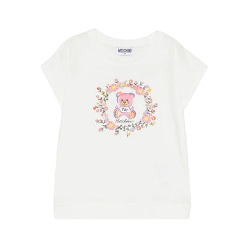 Moschino Kids girls' ivory cotton-blend t-shirt with round neck and short sleeves, featuring a Teddy Bear print surrounded by a floral wreath on the chest, available at Lestyle Boutique 136 Little Collins St.