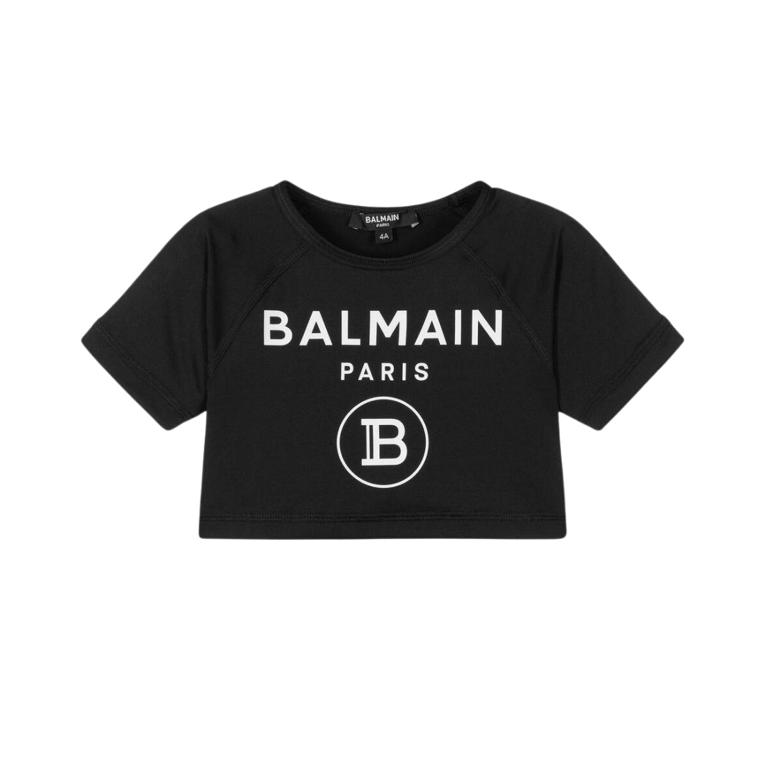 Balmain girls' black cropped t-shirt made from silky polyester jersey, featuring a crew neck, short sleeves, and white Balmain Paris and B logo prints on the front, available at Lestyle Boutique 136 Little Collins St.