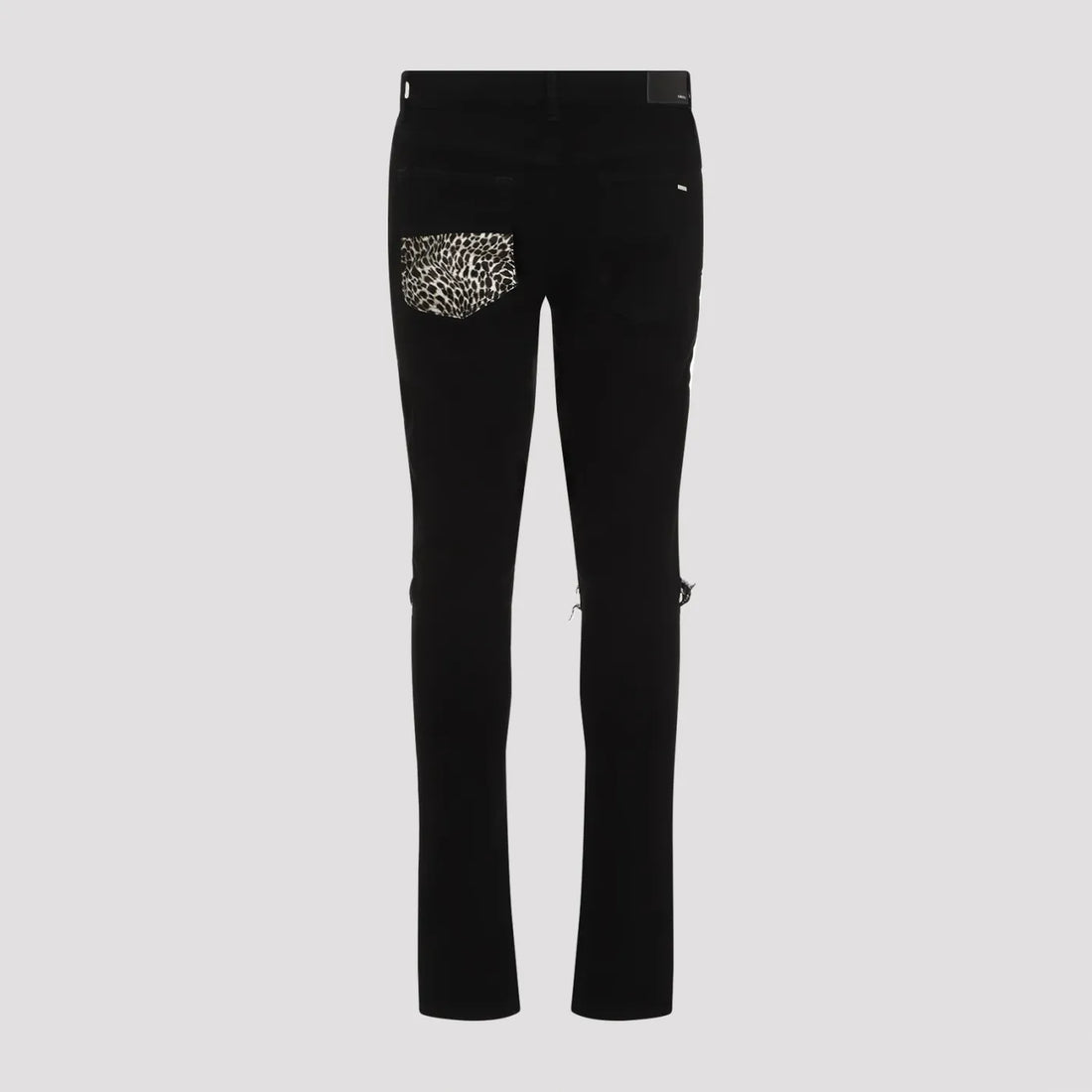 A pair of black stretch skinny jeans by AMIRI, available at Lestyle Boutique. These jeans feature repaired rips with leopard motif inserts, a concealed button closure, and classic five-pocket detailing for a bold and contemporary look.