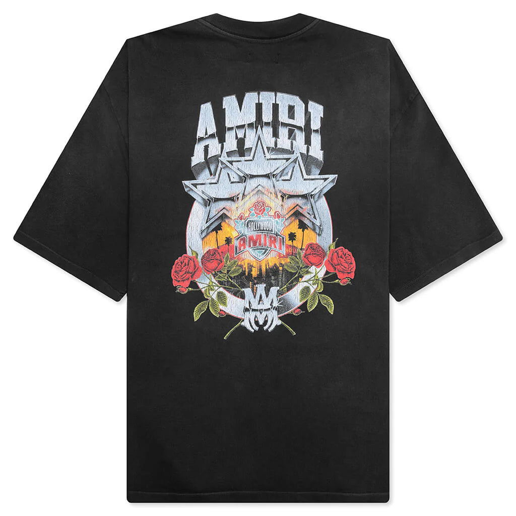 A black oversized championship tee by AMIRI, available at Lestyle Boutique. Featuring bold front and back graphics with distressed details and a vintage wash, this tee combines a statement design with comfort.
