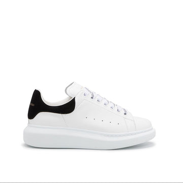 White sneaker with black heel tab on a white background