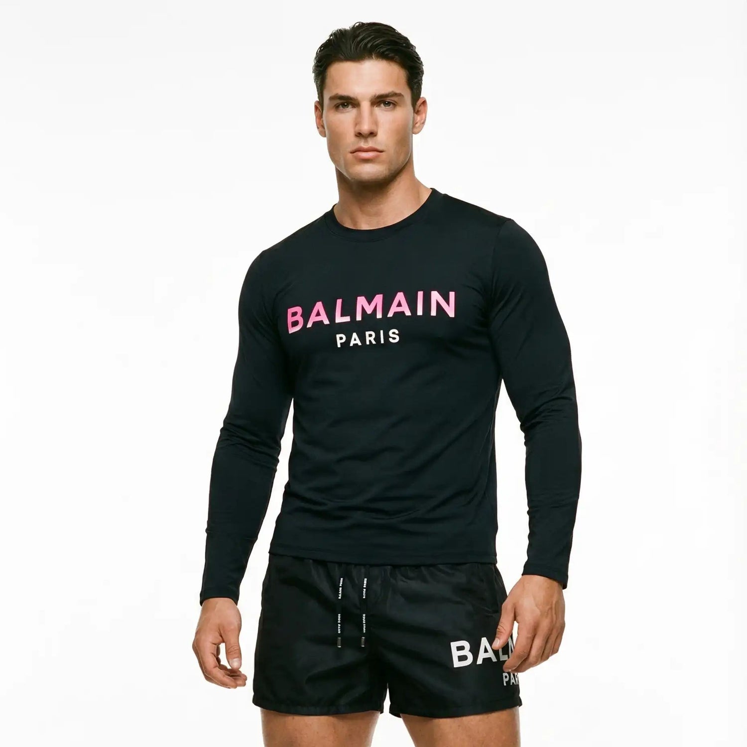 Man wearing a black Balmain Paris long-sleeve shirt and shorts on a white background