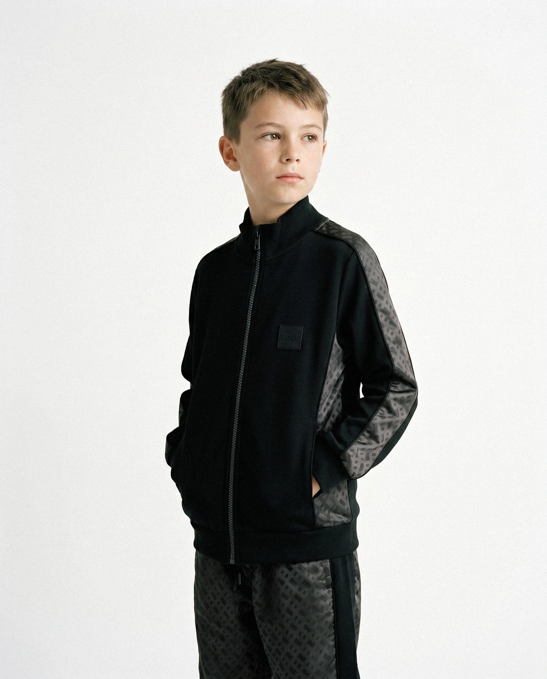 BOSS KIDS black track pants featuring a stylish mesh design and elasticated drawstring waistband. These premium children's pants are designed for comfort with ribbed cuffs and a straight leg fit. Ideal for active kids, these pants are perfect for casual outings or playdates, available at Lestyle Boutique Melbourne.