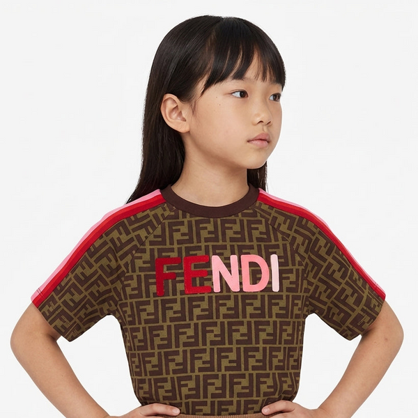 Child wearing a brown Fendi shirt with red accents on a white background