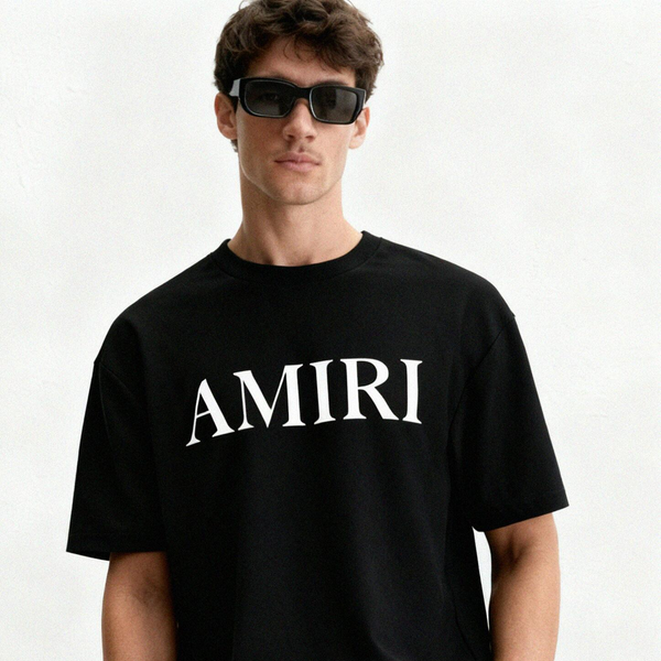 Man wearing a black AMIRI t-shirt on a white background