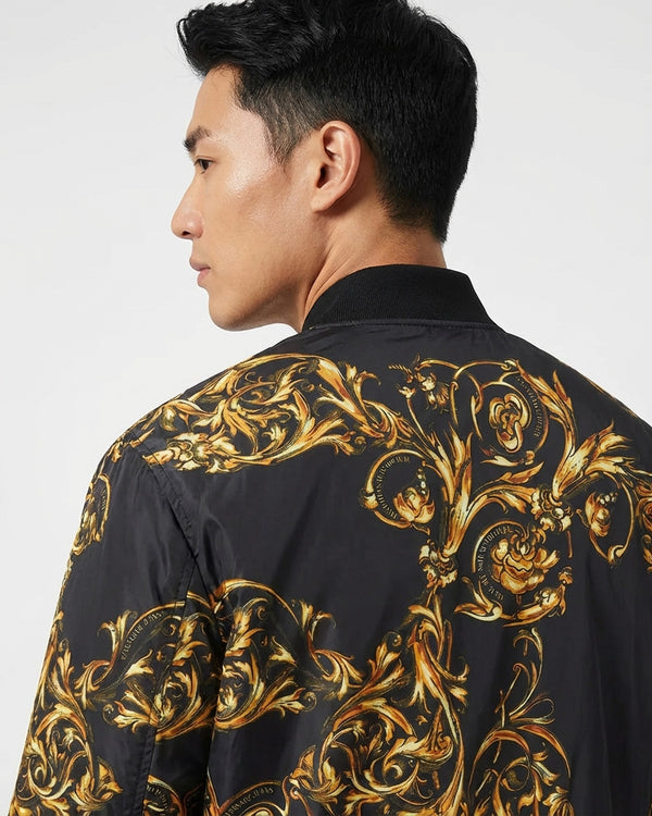Man wearing a black shirt with gold floral patterns on a white background
