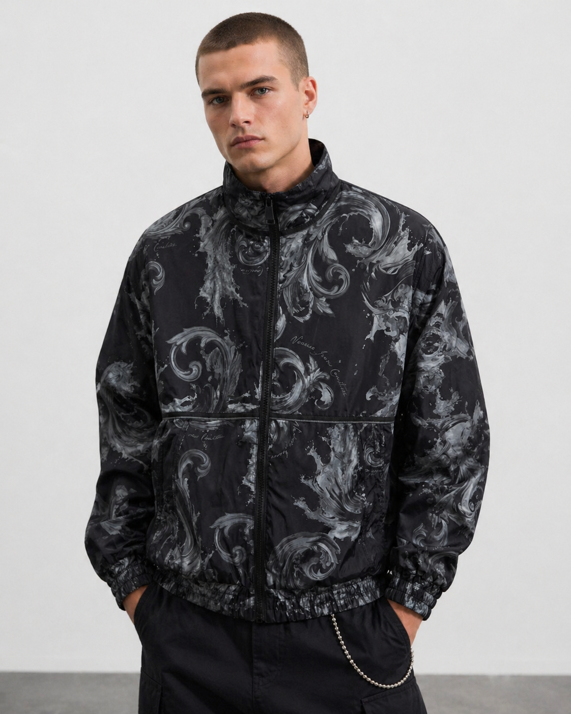 Man wearing a black patterned Versae Jeans Couture jacket against a white background
