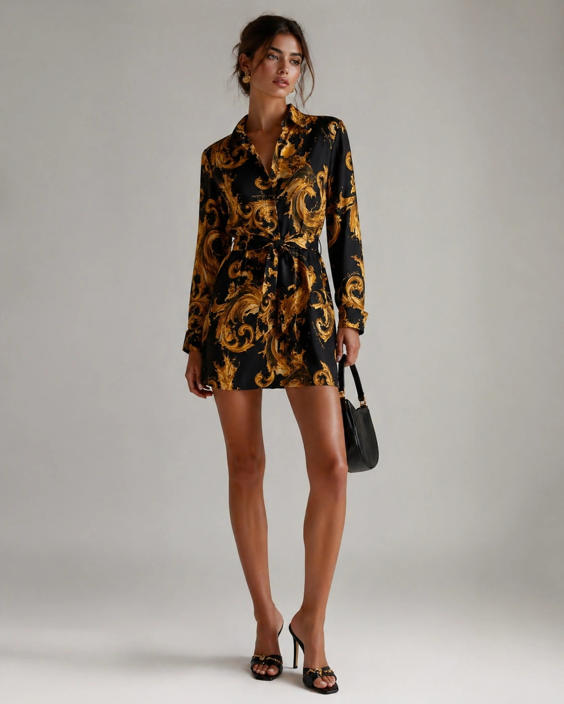 Woman wearing a black and gold patterned dress with a plain background