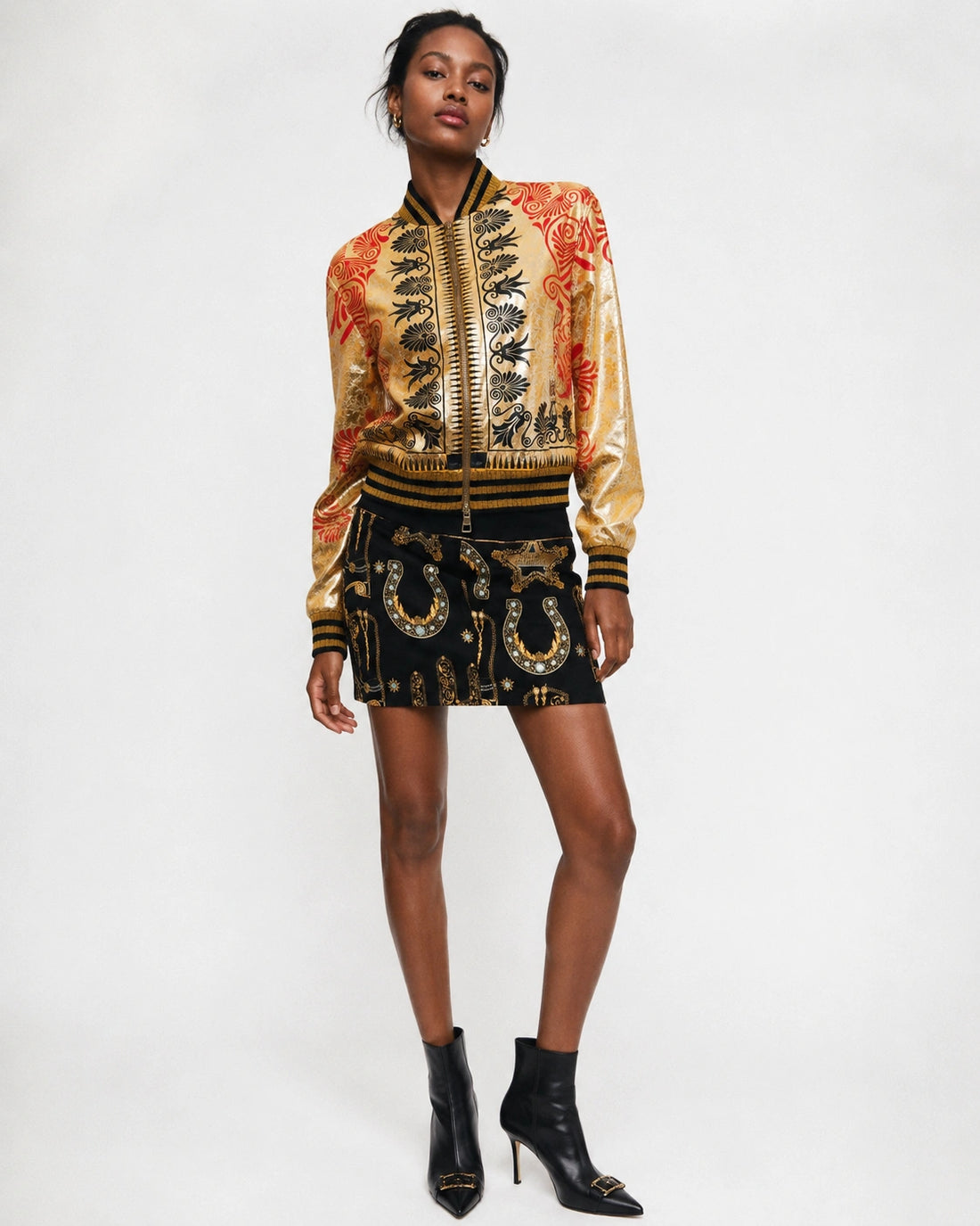 Versace Collection women's cropped bomber jacket in a metallic gold baroque print fabric, featuring a two-way zip fastening, welt pockets, and black and gold striped ribbed collar, cuffs, and hem, available at Lestyle Boutique 136 Little Collins St.