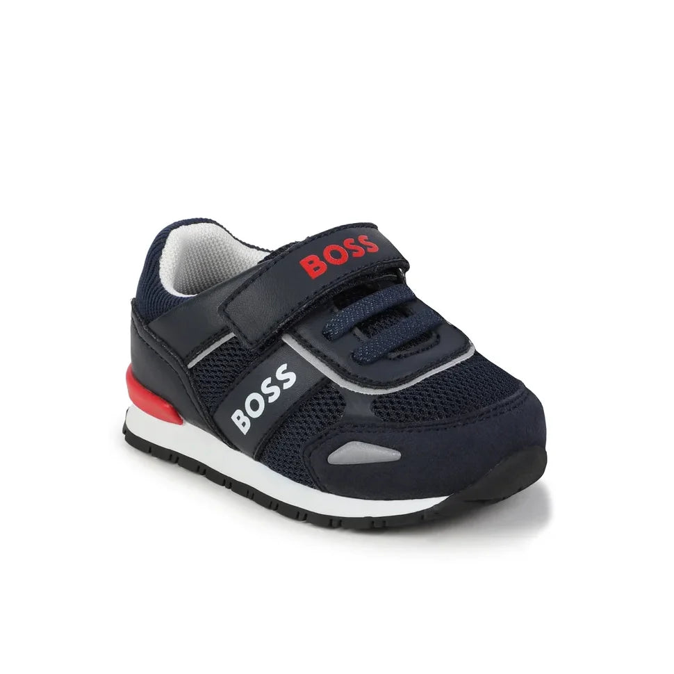 Stylish BOSS Kids navy sneakers featuring a comfortable design with a Velcro strap for easy wear. Constructed from a premium blend of leather and mesh, these shoes showcase red and white logo accents for a trendy look. Ideal for active children, these sneakers offer both style and comfort, making them perfect for everyday wear or casual outings. Available at Lestyle Boutique Melbourne.