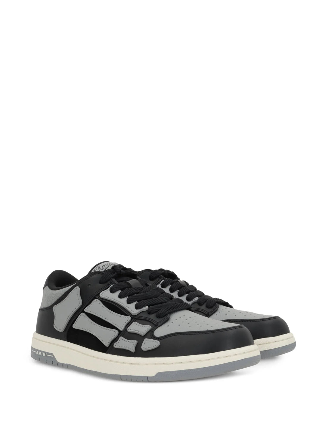 A pair of asphalt grey Skel Top low sneakers by AMIRI, available at Lestyle Boutique. Featuring sewn applications, two-tone rubber sole, and perforated details, these sneakers combine style and comfort effortlessly.