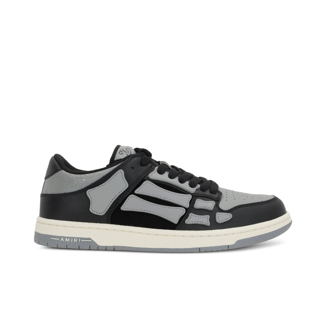 A pair of asphalt grey Skel Top low sneakers by AMIRI, available at Lestyle Boutique. Featuring sewn applications, two-tone rubber sole, and perforated details, these sneakers combine style and comfort effortlessly.