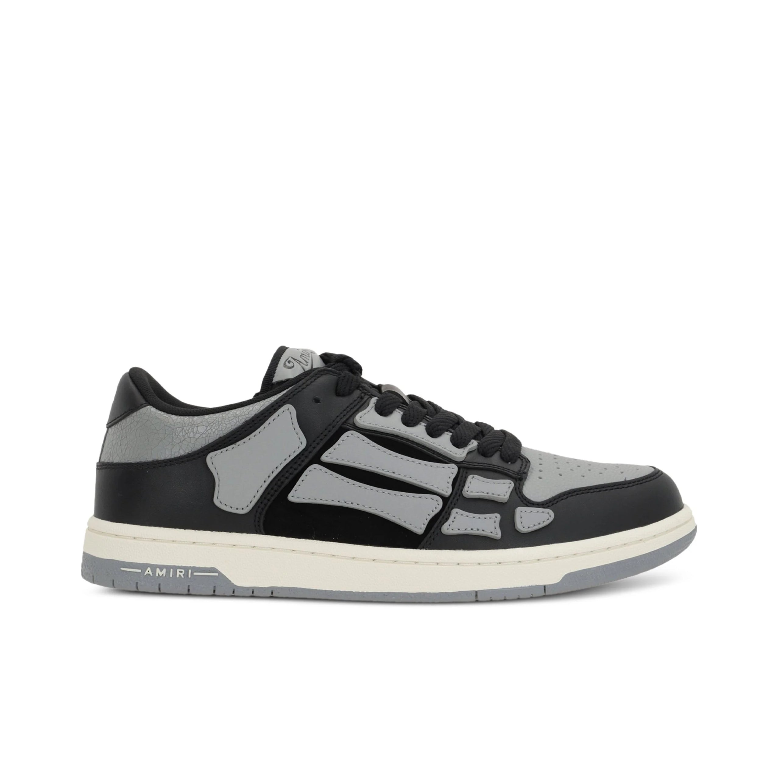 A pair of asphalt grey Skel Top low sneakers by AMIRI, available at Lestyle Boutique. Featuring sewn applications, two-tone rubber sole, and perforated details, these sneakers combine style and comfort effortlessly.