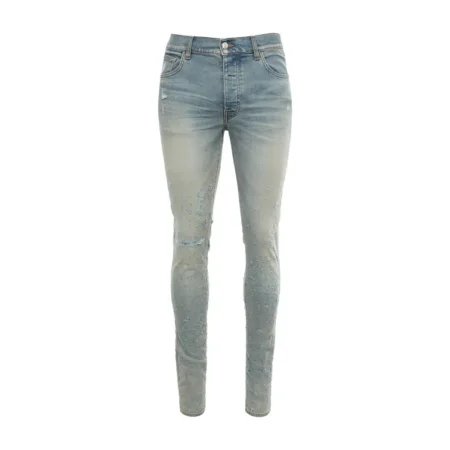 A pair of stretch stonewashed denim jeans by AMIRI, available at Lestyle Boutique. These jeans feature distressed details, a logo label at the back, belt loops, and a concealed button closure for a modern, rugged look.