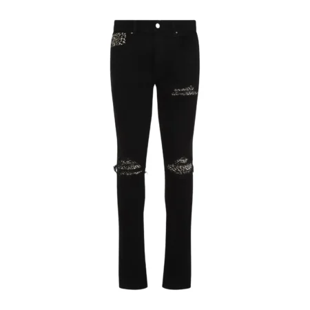 A pair of black stretch skinny jeans by AMIRI, available at Lestyle Boutique. These jeans feature repaired rips with leopard motif inserts, a concealed button closure, and classic five-pocket detailing for a bold and contemporary look.