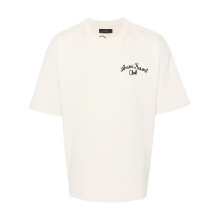 A beige stretch-cotton t-shirt by AMIRI, available at Lestyle Boutique. Featuring embroidered logos on the chest and back, this tee combines comfort and elegance with a resort-inspired aesthetic.